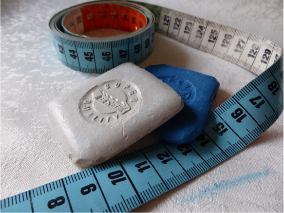 Measuring tape and tailor’s chalk used for accurate performance-wear fittings.