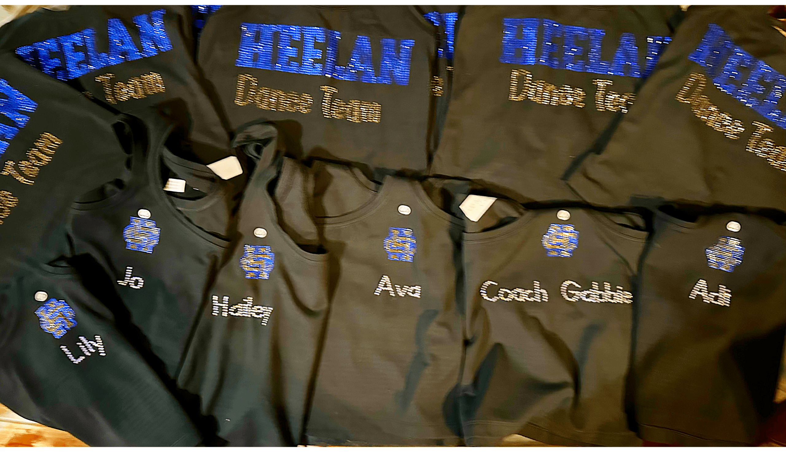 Heelan High School team members in black rhinestone tops with the school logo and personalized names.