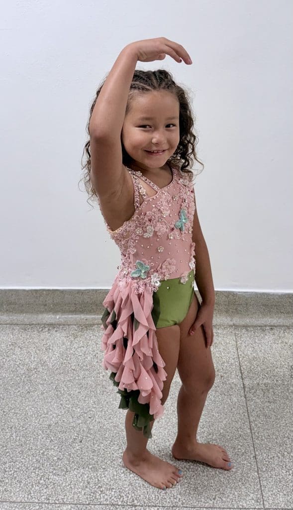 girl in a custom competitive costume lyrical pink and green